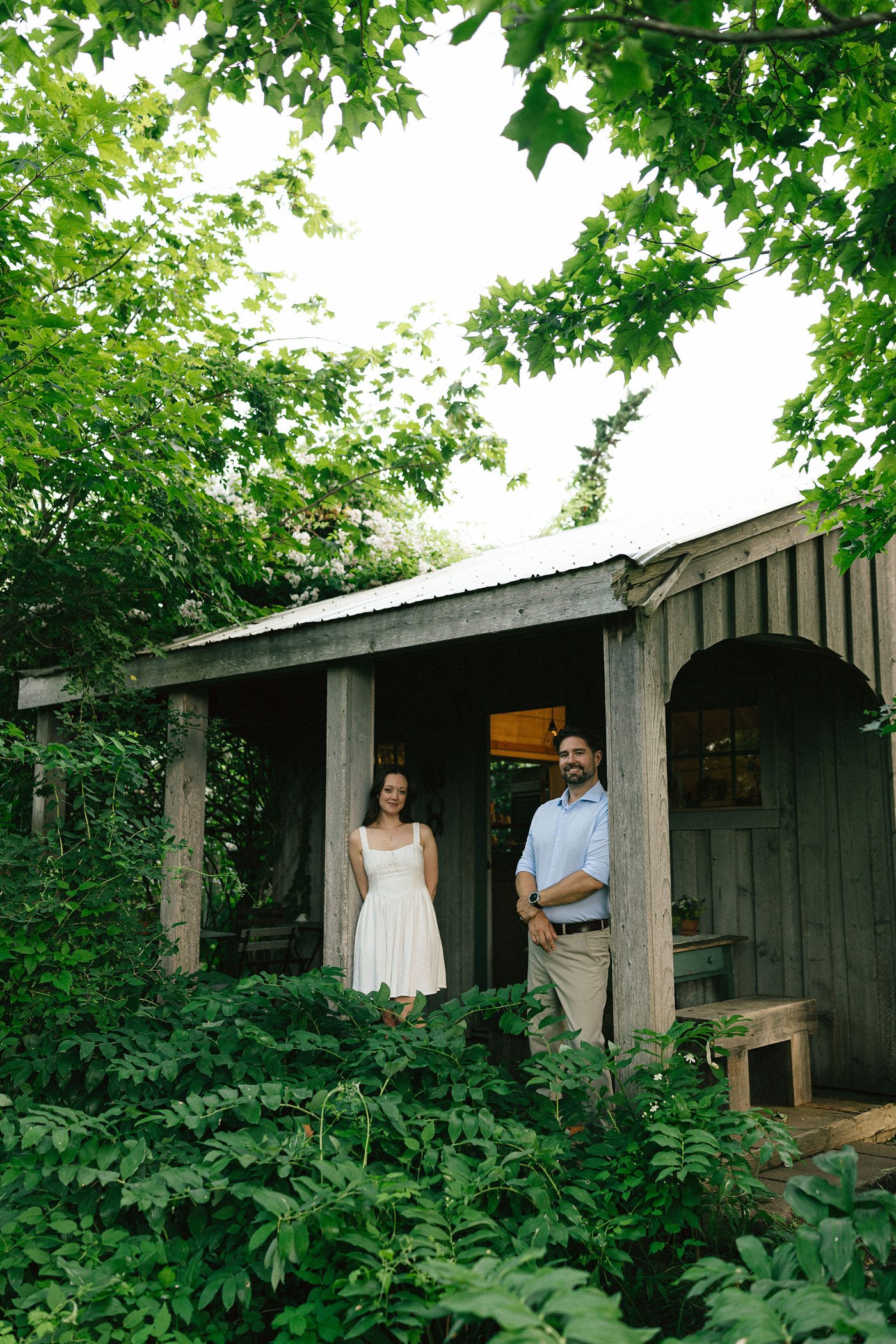 Danielle and Brenden standing together outside a garden cottage