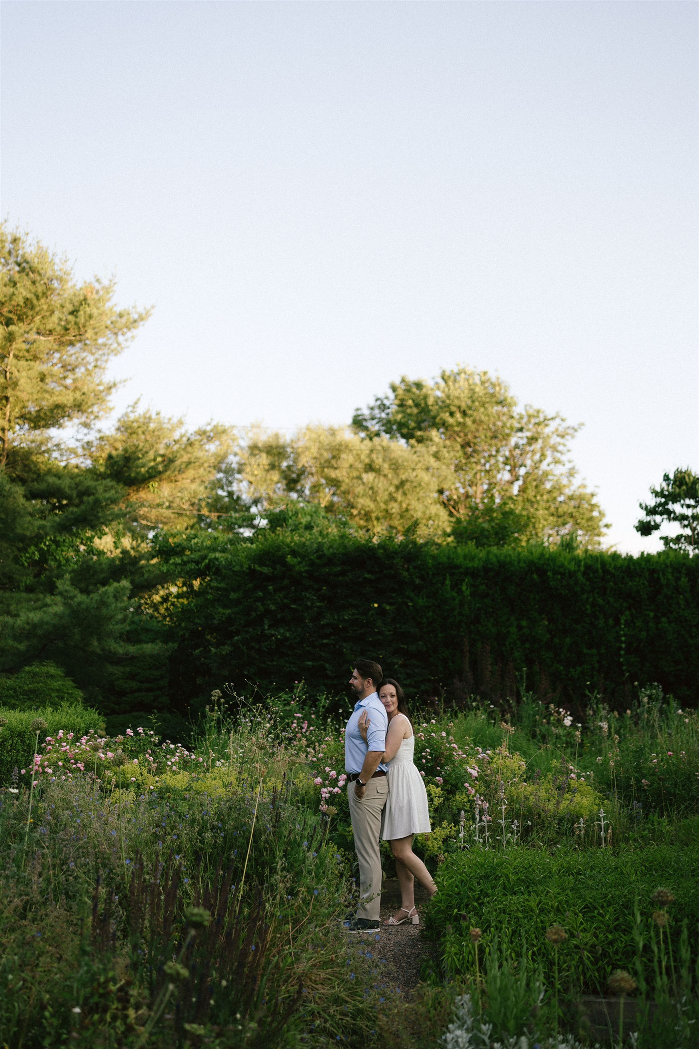 Danielle and Brenden standing together in a meadow